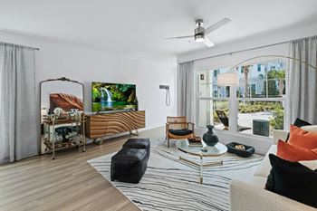 a living room with a couch and a table and a large window at Altis Grand Suncoast, Land O' Lakes Florida